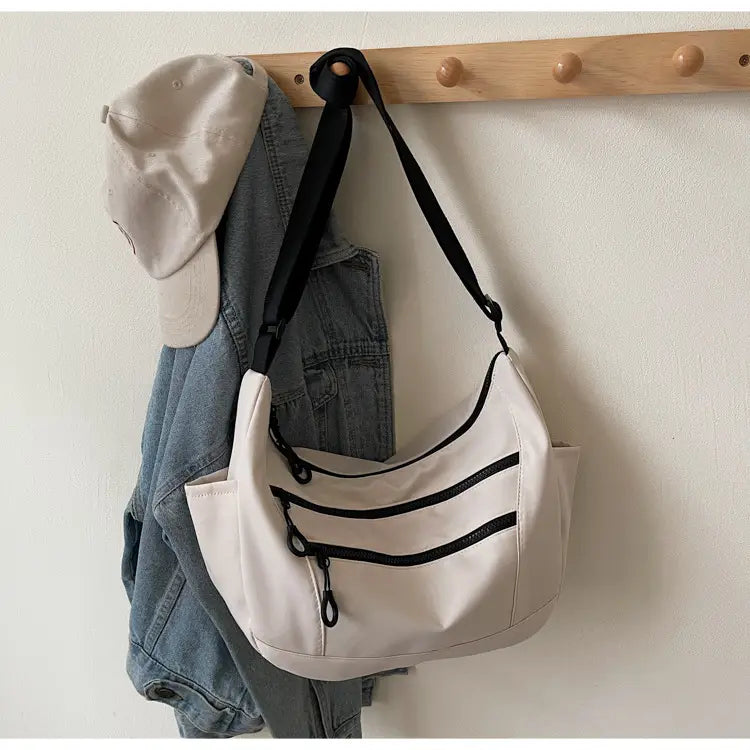 Lerret dumpling pose medium crossbody veske med glidelåslomme for kvinner