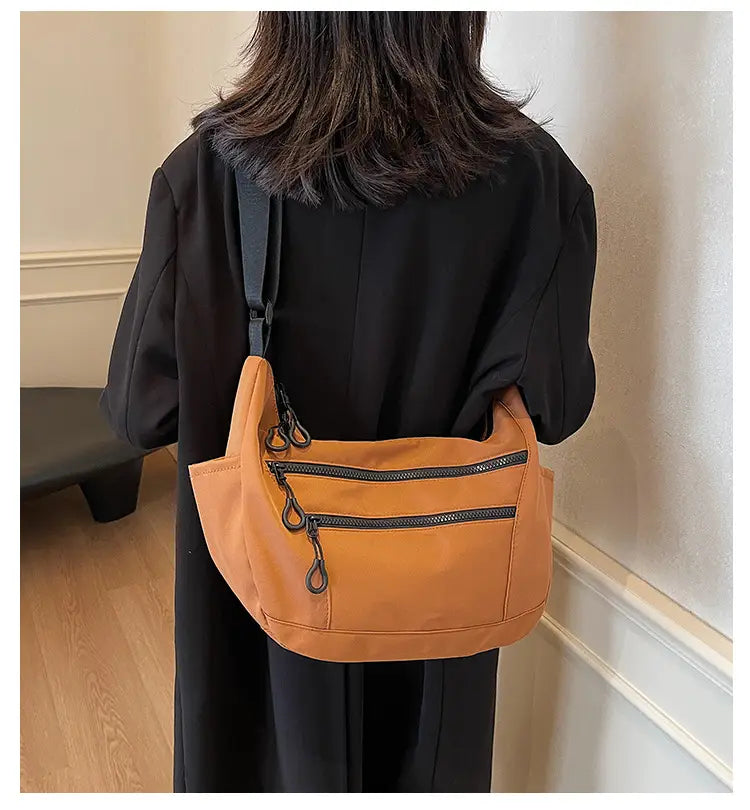 Lerret dumpling pose medium crossbody veske med glidelåslomme for kvinner